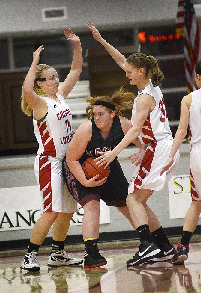 Linn sophomore Erika Stefka (55) attempts to get past Calvary Lutheran senior Kara Wehmeyer (14) and freshman Sam Gumm (34) on Thursday night at Calvary's new gym.