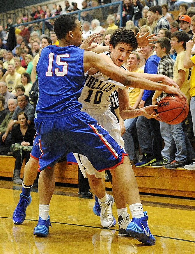 Helias guard Sam Husting and Moberly forward Will Rucker battle for possession of the ball during Friday's game at Rackers Fieldhouse. Helias defeated Moberly 57-37 to improve to 9-2 on the season.