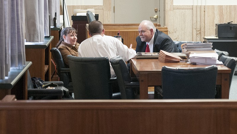 Sandra Plunkett, 40, of Holts Summit speaks with her defense council on Friday as jury deliberates. 