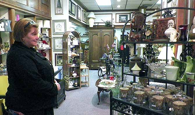 Melissa Williams, Centertown, browses the newly placed items for sale at The Copper Tree Exchange, now located
at 112 E. High St. Williams came Friday to check out the shop's new location on its first day of business in its new
Jefferson City location.