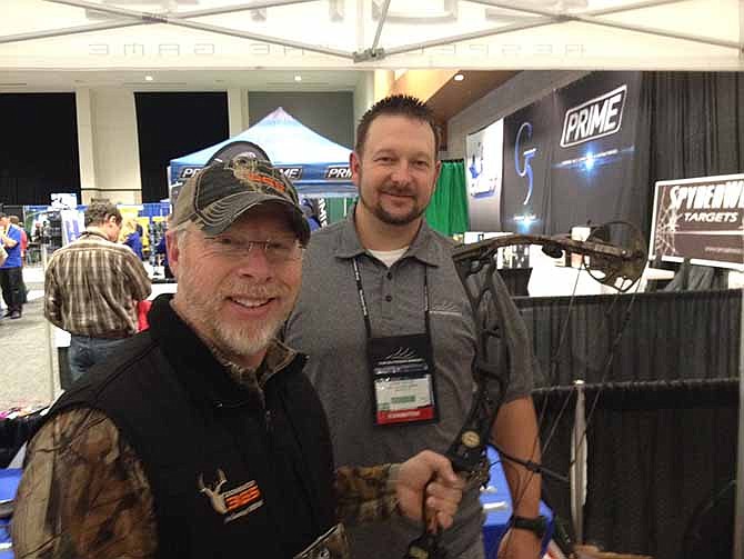 
Missouri-based sales representative Larry McCoy (left) shows Phillip Vanderpool a new bow from Elite Archery.