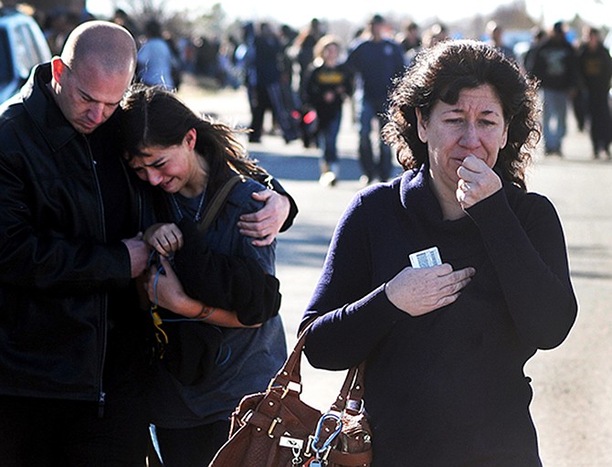 A woman waits at a staging ground area on Tuesday where families are being reunited with Berrendo Middle School students after a shooting at the school in Roswell, N.M. 