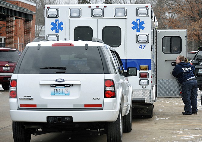 An EMT confers with an ambulance driver outside St. Joseph School after a dozen children became ill Wednesday morning.