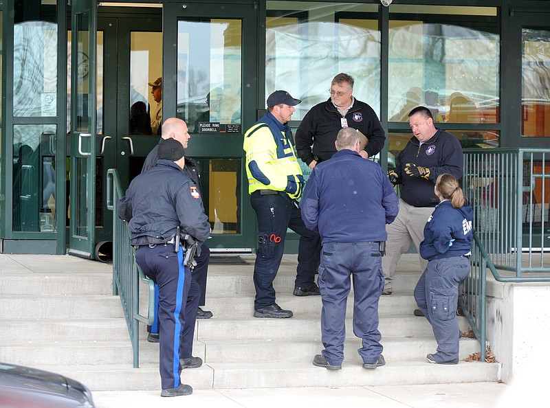 Emergency medical personnel discuss the activities at St. Joseph Cathedral School Wednesday morning.