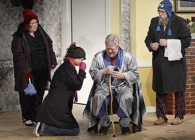 Sara Benjamin (played by Kayla Norton) cries at the feet of her ailing father, Joe Benjamin (played by Rob Hargis) while Mady and Morris (played by Tammy Stains and Thom Kirk respectively) look on in the theatrical production "God's Favorite" put on by the Stained Glass Theatre.