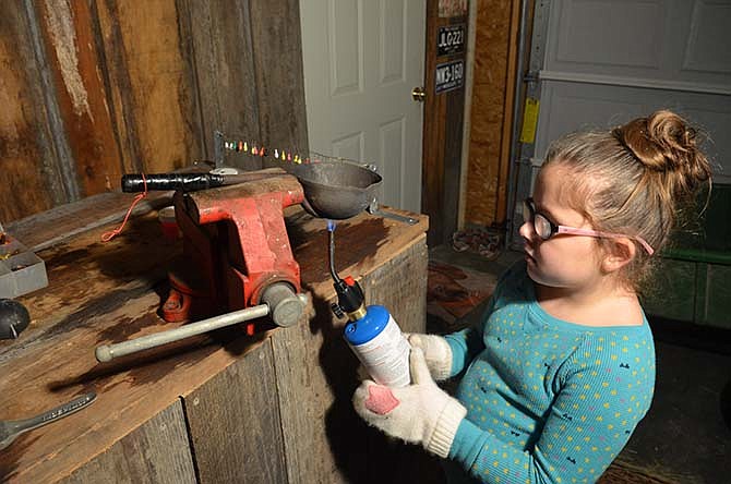 Annabel Butler helps her father melt lead for homemade crappie jigs.