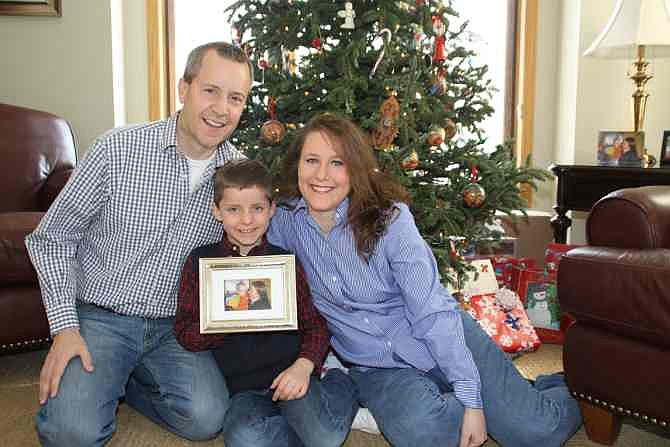This December 2012 photo provided by the family shows, from left, John, Jack and Renee Thomas at their home in Minnetrista, Minn. Jack was adopted from Russia in 2008. At the time the Russian ban on adoptions by Americans was imposed in 2013, the family was trying to adopt Jack's biological brother, Nikolai.