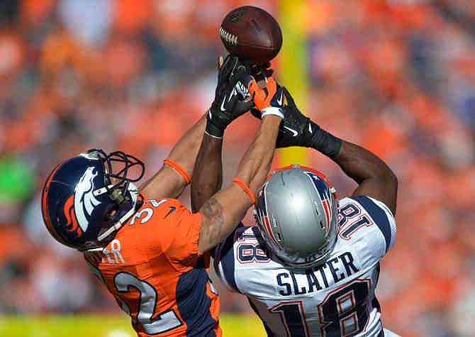 Denver Broncos cornerback Tony Carter (32) breaks up a pass intended for New England Patriots wide receiver Matthew Slater (18) during the first half of the AFC Championship NFL playoff football game in Denver, Sunday, Jan. 19, 2014.
