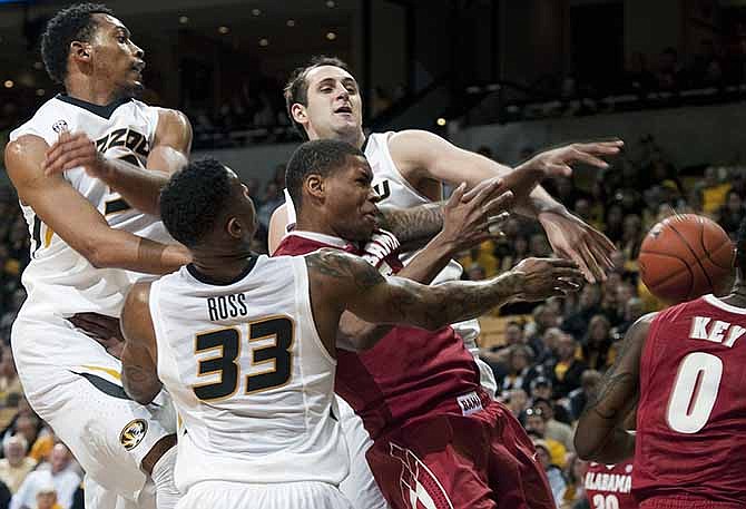 Missouri's Johnathan Williams III, left, Earnest Ross (33) and Ryan Rosburg knock the ball away from Alabama's Nick Jacobs during the second half of an NCAA college basketball game, Saturday, Jan. 18, 2014, in Columbia, Mo. Missouri won the game 68-47.