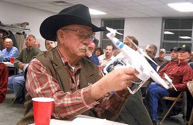 In this Jan. 9, 2014 photo, Jim McCann, president of the Missouri Cattlemen's Association, inspects a drone that could be used to check on cattle on his farm in Lawrence County, Mo. He was among more than 100 farmers who attended the 90th annual Lawrence County Soils and Crops Conference in Mount Vernon, Mo. (AP Photo/The Joplin Globe, Katie Lamb)