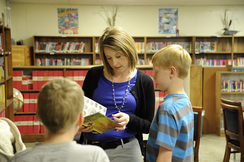 Russellville Elementary librarian Tina Kauffman helps fourth graders during a "Dewey Hunt," a play on duck hunt as part of the year's incentive theme based on the A&E reality television show "Duck Dynasty." 