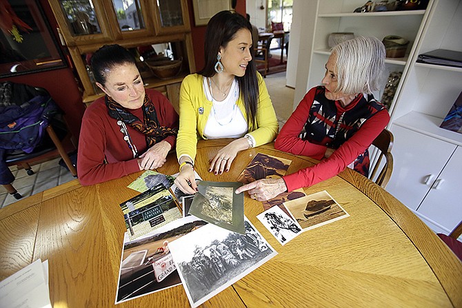 Mia Prickett, middle, shares a collection of family photos with great aunts Marilyn Portwood, right, and Val Alexander in Portland, Ore.
