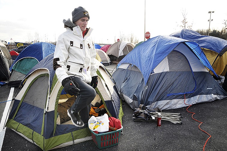 Jefferson City resident Travis Roberts climbs out of his tent Wednesday morning as he prepares to spend the day waiting in line. He is a Mizzou student and said he's been waiting for about 12 years for there to be a Chick-fil-A in Jefferson City so he wanted to be one of the "First 100." 