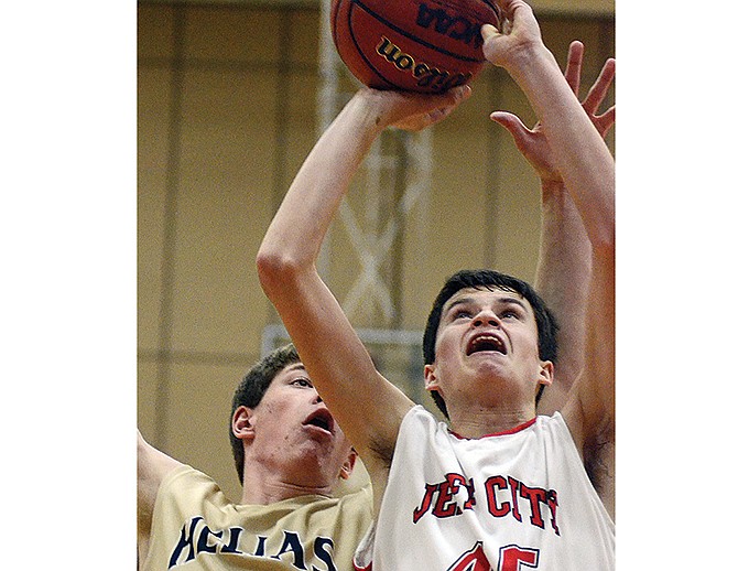 Seth Stegeman of the Jays puts up a shot against the defense of Casey McCollum of Helias during the third quarter of Tuesday night's game at Fleming Fieldhouse.