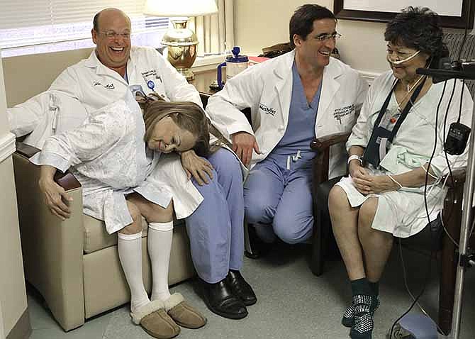 In this Jan. 14, 2014 photo, Anna Williamson, left, clowns around with her surgeon Dr. Matthias Loebe, second from left, as her sister Irma Myers-Santana, right, visits with her surgeon Dr. Scott Scheinin, second from right, in a hospital room in Houston. Earlier this month the sisters ended up in the same operating room, each getting one lung from the same donor. 