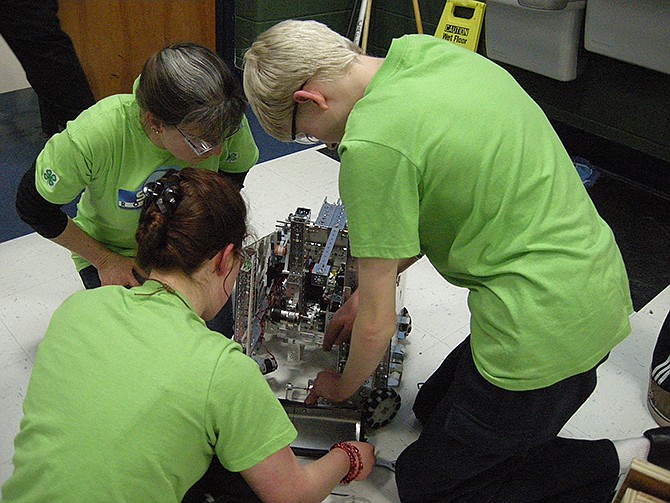 Mentor Anne-Marie Scott and 4-H club members Brenna Scott and Lucas Winkelman work on their robot at a qualifying competition - the Missouri FIRST Tech Challenge - on Jan. 18 in Ballwin.
