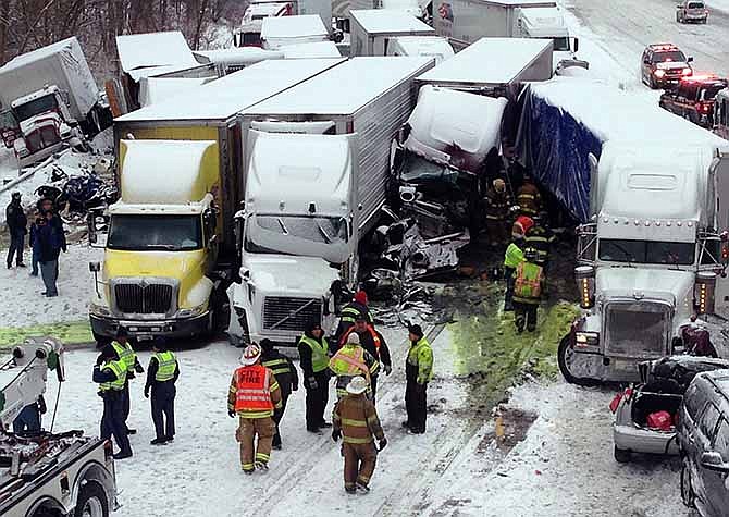 Emergency crews work at the scene of a massive pileup involving about 15 semitrailers and about 15 passenger vehicles and pickup trucks along Interstate 94 Thursday afternoon near Michigan City, Ind. At least three were killed and more than 20 people were injured.