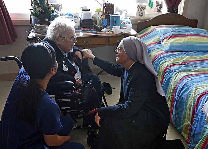 Mother Patricia Mary, right, and nurse Friary Nguyen visit 99-year-old resident Helen Reichenbach in her room at the Mullen Home for the Aged, run by Little Sisters of the Poor, in Denver, Thursday Jan. 2, 2014. 