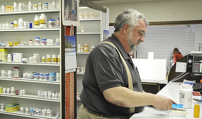 In this Jan. 28, 2014 photo, pharmacist Leroy Stahlman counts capsules as he prepares to fill a prescription at Tolson's Drugs in downtown Jefferson City. Proposed legislation would require monitoring of prescribing and dispensing of controlled substances. 