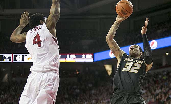 Missouri guard Jabari Brown (32) shoots over Arkansas guard Coty Clarke (4) during the second half of an NCAA college basketball game on Tuesday, Jan. 28, 2014, in Fayetteville, Ark. Brown scored 24 points as Missouri defeated Arkansas 75-71. 