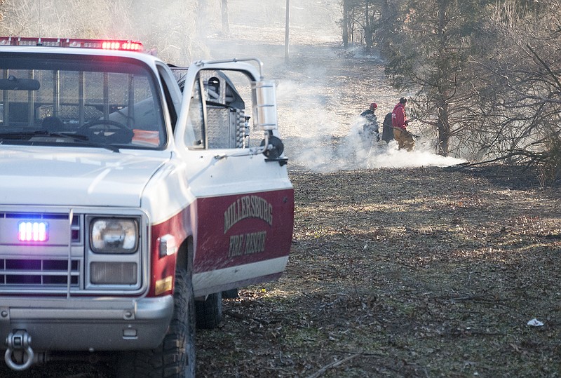 Firefighters from the Millersburg, Boone County and Central Callaway fire departments work together to finish putting out a grass fire in Millersburg off of County Road 351 Tuesday, Jan. 28, 2014.