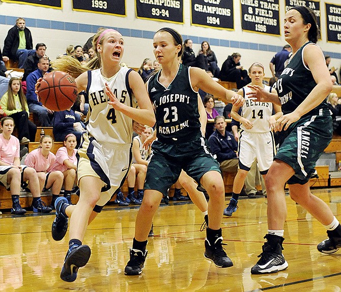 Heiias guard Luci Francka drives around St. Joseph Academy's Nikki Tracy (23) during Wednesday's game at Rackers Fieldhouse.