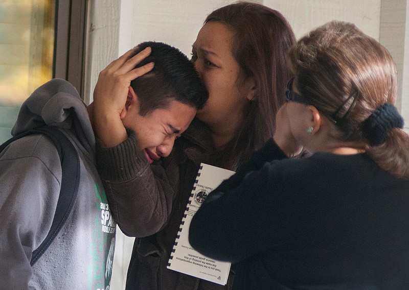 A Sparks Middle School student is comforted as he cries after being released from Agnes Risley Elementary School, where some students were evacuated to after a 2013 shooting, in Sparks, Nev. 
