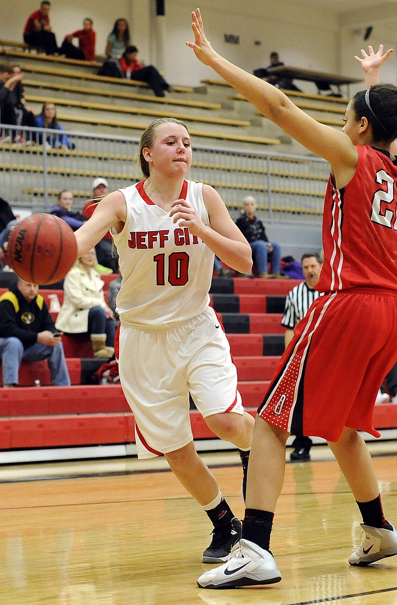 Jefferson City's Tayler LePage fires a baseline bounce pass around Ozark's Sasha Robinson during Monday night's game at Fleming Fieldhouse.