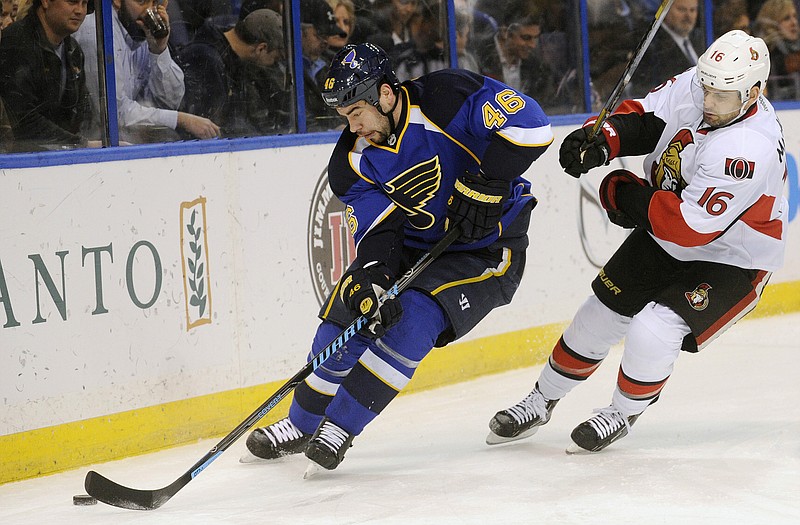 Roman Polak of the Blues skates around Clarke MacArthur of the Senators during the first period of Tuesday night's game in St. Louis.