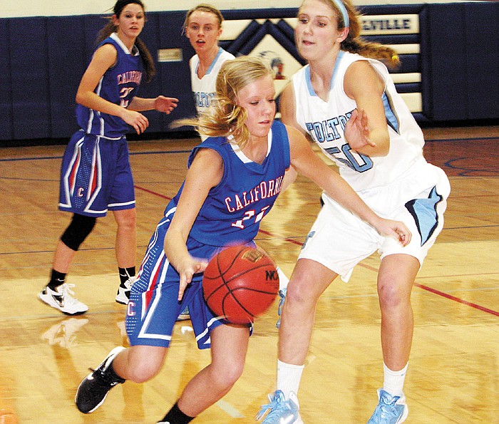 California's Morgan Henley (11) drives past Father Tolton's Kendall Condict during the championship game Thursday night at the Russellville Tournament. The Lady Trail Blazers won 49-44. 