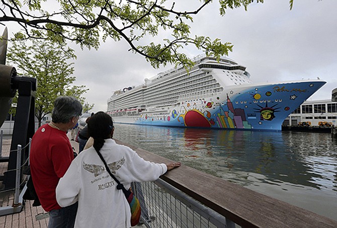 People pause to look at Norwegian Cruise Line's new ship, Norwegian Breakaway, on the Hudson River in New York. A 4-year-old child died after being pulled unresponsive from a swimming pool on the Norwegian Breakaway, off the coast of North Carolina on Monday. Crew members were able to revive a 6-year-old boy also found in the pool. He was airlifted to a hospital, where his condition was unknown. 