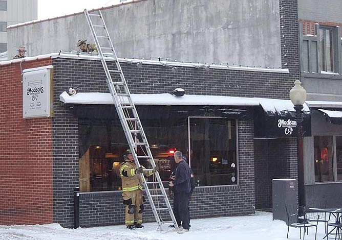 Jefferson City firefighters climb to the roof of Madison's on Tuesday evening, where they determined it was a failed motor on a heating unit that caused the restaurant to fill with a smoky smell. There was no fire.
