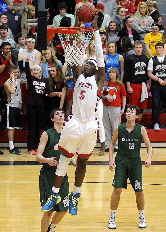 Jefferson City's O.G. Anunoby drives past Marquette's Spencer Osterman (42) and Jason Powers (12) and slams home a fourth period dunk in front of the Jays' student section.