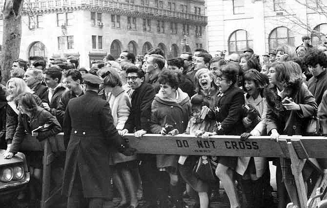 This Feb. 7, 1964 file photo shows fans pushing forward in hopes of getting a view of The Beatles after their arrival for an American tour in New York. Sunday marks the 50th anniversary of The Beatles' performance on "Ed Sullivan," their first appearance in America. 