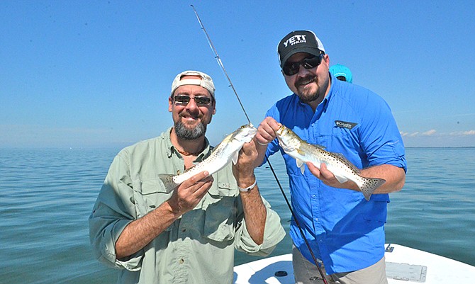 Dan Stefanich (left) and Brandon Butler pose with a couple of sea trout caught just off shore from Captiva Island. The four-man fishing trip landed more than 100 fish during a four-hour trip.