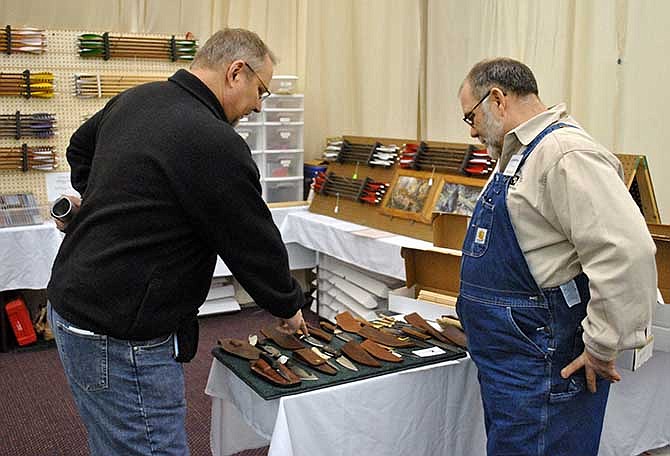 Jim Pyles, right, of JP Enterprises in St. Mary, discusses some of his knives with United Bowhunters of Missouri member and festival guest Allen Bock, Columbia. Pyles' business, which started in 2000, receives a lot of business during the event, primarily for his custom arrows and leatherwork pieces.