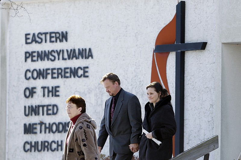 Accompanied by his wife Brigitte, right, the Rev. Frank Schaefer, of Lebanon, Pa., center, departs after a meeting with officials at the Eastern Pennsylvania Conference of the United Methodist Church in Norristown, Pa. Church officials have defrocked Schaefer, who officiated his son's gay wedding in Massachusetts.