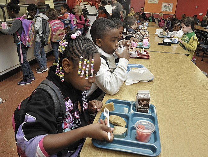 Amarriah Lee, near, and Nehemiah Hamilton, both second-grade students at East School, enjoy their breakfast before the start of the day's classes. Jefferson City Public Schools are facing a budget shortfall due to protested tax bills.