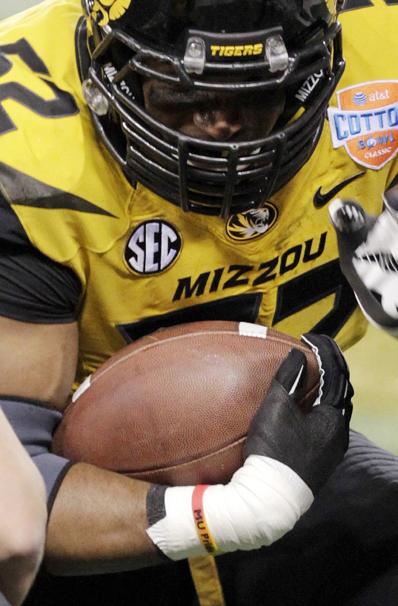 In this Jan. 3 photo, Missouri defensive lineman Michael Sam goes through warmups before the Cotton Bowl wearing an "MU Pride" bracelet on his right wrist made by Triangle Coalition, a student organization for lesbian, gay, bisexual and transgender people.