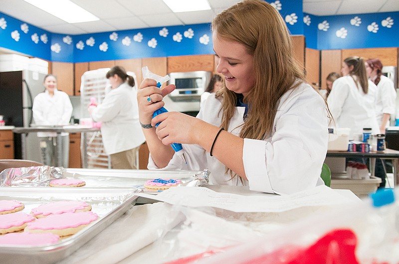 A South Callaway High School student smiles as she decorates cookies Tuesday during the Bulldog Bakeshop class. The 2013-14 school year is the first for the baking class. It's an addition to the school's culinary curriculum, which is certified through the National Restaurant Association.