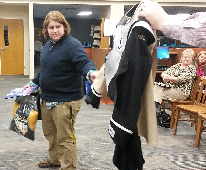 Kelly Neudecker, Fulton High School band director, shows a sample similar to the new uniforms for the marching band to the school board Tuesday. The board approved the purchase of new uniforms, scheduled to arrive Aug. 1.