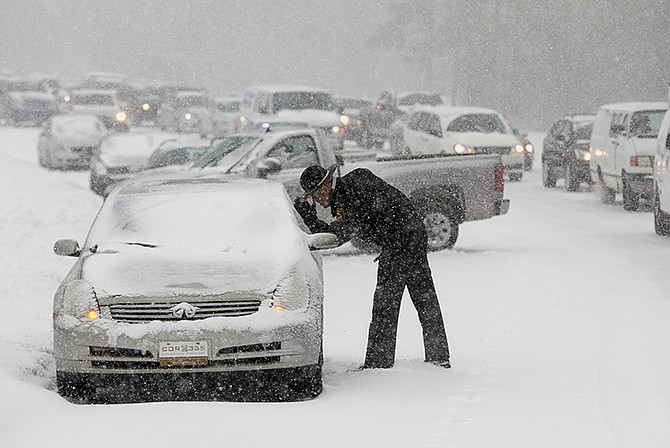 A Highway Patrol officer checks on the safety of a stranded motorist during a winter storm Wednesday in Raleigh, N.C.