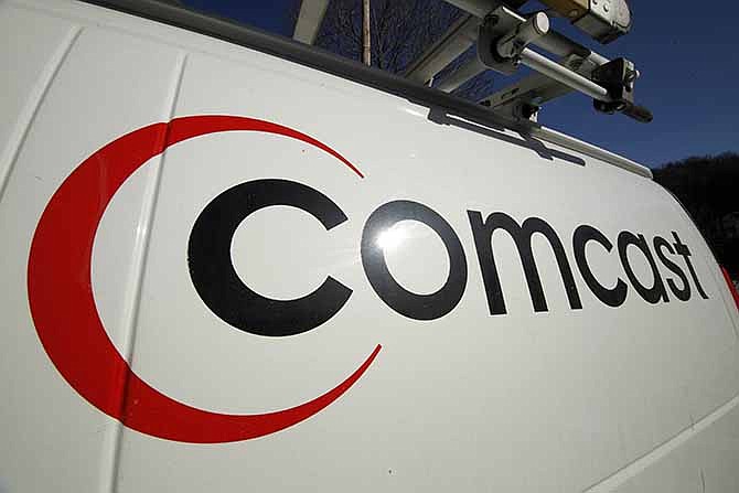 This Feb. 11, 2011 file photo shows the Comcast logo on one of the company's vehicles, in Pittsburgh. Comcast has agreed to buy Time Warner Cable.