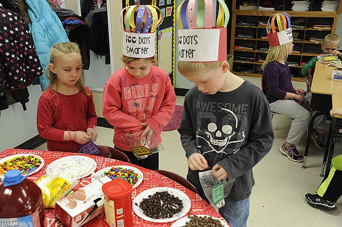 Austin Colvin, Shaelyn Boessen and Kyla Dawson build their 100th Day of School Trail Mix by counting 10 pieces of 10 snack items into their baggies Thursday.