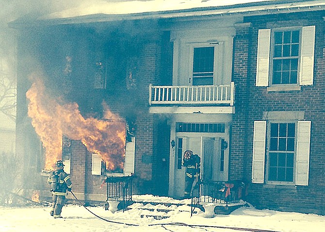 Fulton firefighters work to contain a fire Thursday morning on Jefferson Street. Chief Dean Buffington said it took crews about 20 minutes to contain the blaze, but said they likely would be "chasing hot spots" through the afternoon.