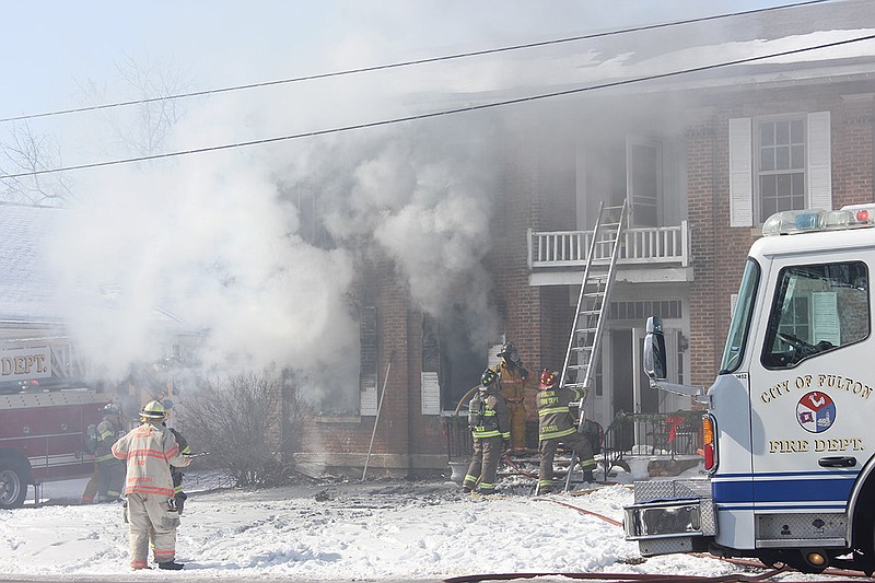 Fulton firefighters work to contain a fire on Jefferson Street Thursday morning. Chief Dean Buffington said it took crews about 20 minutes to contain the blaze, but said they likely would be "chasing hot spots" through the afternoon.