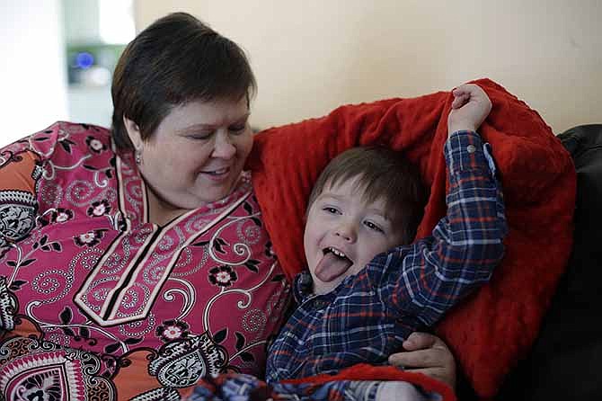 In this Monday, Feb. 3, 2014, photo, Mary-Jane Harrison plays with her grandson David, in San Antonio. Like nearly 78 million American adults, Harrison is obese, and because of stress fractures in her legs she is unable to able to walk up or down the stairs of her two-story home.