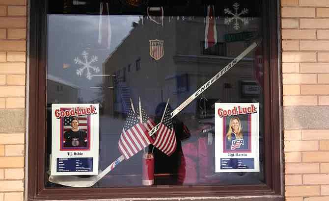 This photo provided by Marnie Swedberg shows the storefront window of Two Friends Treasures in Warroad, Minn., a town that's remarkably successful at producing Olympic hockey greats despite having fewer than 2,000 residents, on Saturday, Feb. 15, 2014 The hockey notables include T.J. Oshie, who led the U.S. men's Olympic team to a 3-2 shootout win over Russia on Saturday.