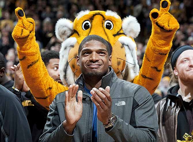 Missouri's All-American defensive end Michael Sam claps during the Cotton Bowl trophy presentation at halftime of an NCAA college basketball game between Missouri and Tennessee, Saturday, Feb. 15, 2014, in Columbia, Mo. Sam came out to the entire country Sunday, Feb. 9, and could become the first openly gay player in the NFL. 