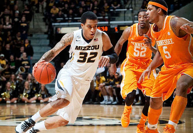 Missouri's Jabari Brown, left, dribbles around Tennessee's Jamell Stokes, right, and Jordan McRae during the first half of an NCAA college basketball game Saturday, Feb. 15, 2014, in Columbia, Mo.